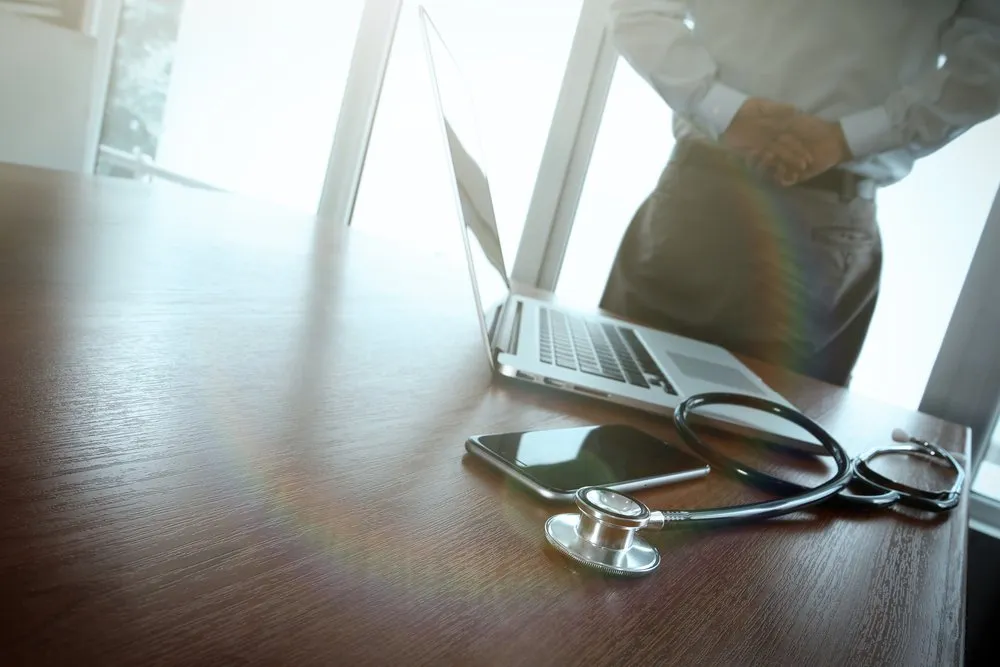 Escritorio médico con un computador portátil y un estetoscopio