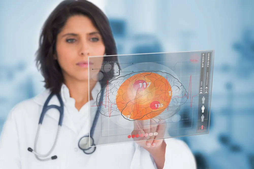 Doctora que revisa una imagen del cerebro en una pantalla transparente